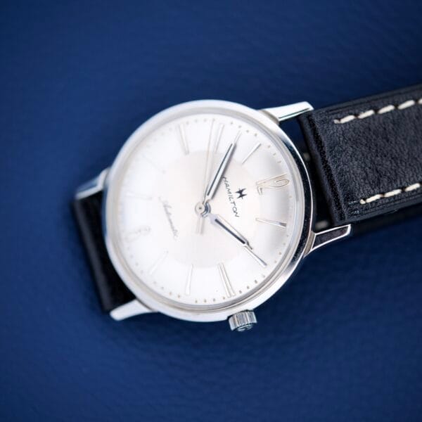 The Hamilton Accumatic X Sunburst Dial Stainless Steel Cal. 667 wristwatch features a striking sunburst dial and comes with a stylish black leather strap.