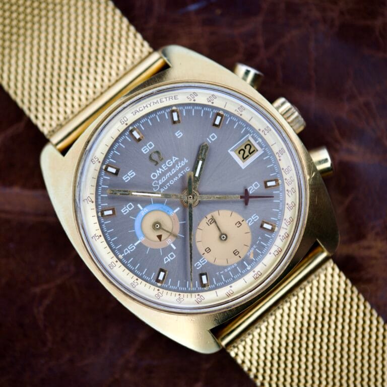 Omega Seamaster Chronograph Ref. 176.007 with gold case, mesh band, grey dial, automatic Cal. 1040 movement, subdials, and date at 3 o’clock.