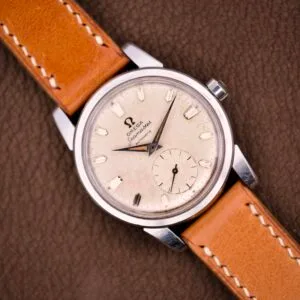 An Omega Seamaster Automatic Ref. 2848 Stainless Steel Cal. 490 with a tan leather strap displayed on a brown textured surface.