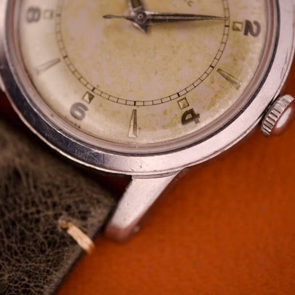 Side profile of the Tissot 6590 stainless steel case showing the short sharp lugs and the 4 and 6 applied steel Arabic numerals.