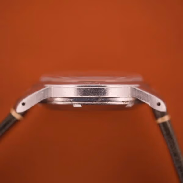 Pure side view of the Tissot Ref. 6590 stainless steel case showing the snap caseback profile and the slim mid-century proportion of the lugs.