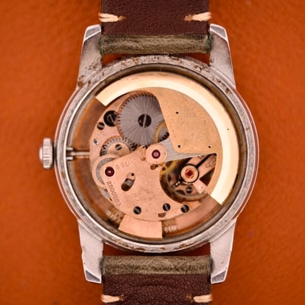 Tissot caliber 28.5R-21 bumper automatic seen through the open caseback of Ref. 6590, with the 120-degree rotor and the banking springs visible.