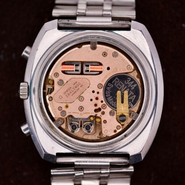 Close-up of an open Omega Seamaster Speedsonic F300 Ref. 188.0002 Chronograph case, showing detailed internal electronic components and battery, original bracelet, and Spanish date display.