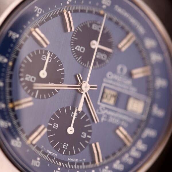 Close-up of a blue Omega Seamaster Speedsonic F300 Ref. 188.0002 chronograph watch face with original bracelet and Spanish date display, echoing the iconic design of this classic timepiece.