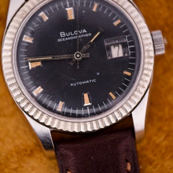Close-up of a Bulova Oceanographer Automatic Date watch, featuring a black dial and fluted bezel.