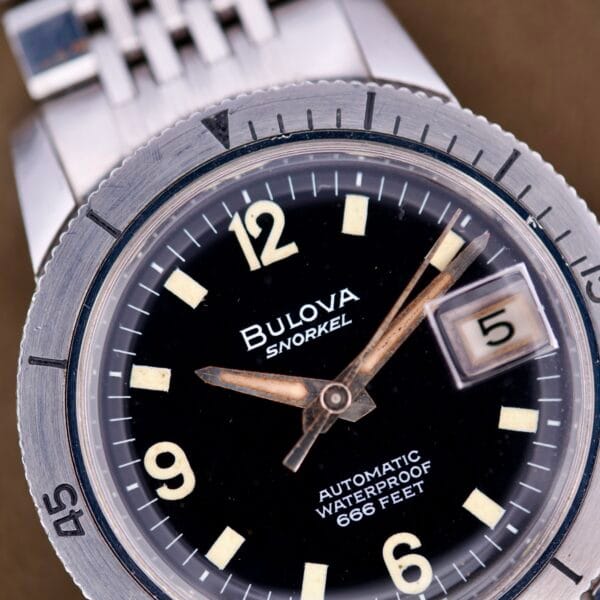 Close-up of a Bulova Snorkel Automatic Devil Diver Ref. 386 with black dial, date set to 5, and water resistance indicated at 666 feet.