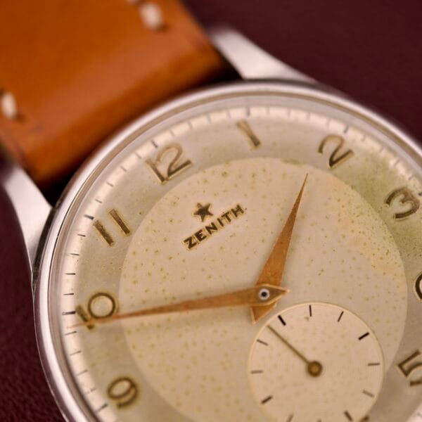 Close-up of a Zenith Caltrava Jumbo featuring a stainless steel case, Arabic numerals, subseconds dial, gold hands, and a tan leather strap.