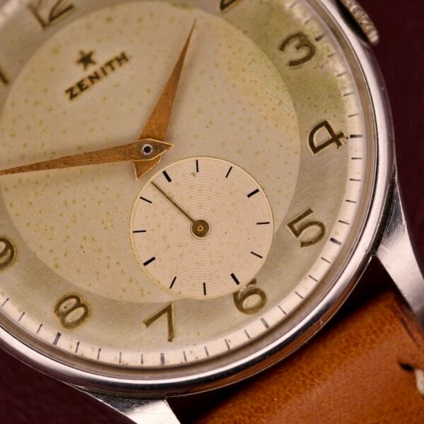 Close-up of a Zenith Caltrava Jumbo wristwatch featuring a stainless steel case, Arabic numerals, subseconds dial, and brown leather strap.