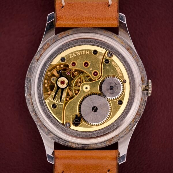 Close-up of the Zenith Caltrava Jumbo watch featuring an exposed mechanical movement, Arabic numerals on the dial, a subseconds display, and housed in a stainless steel case.