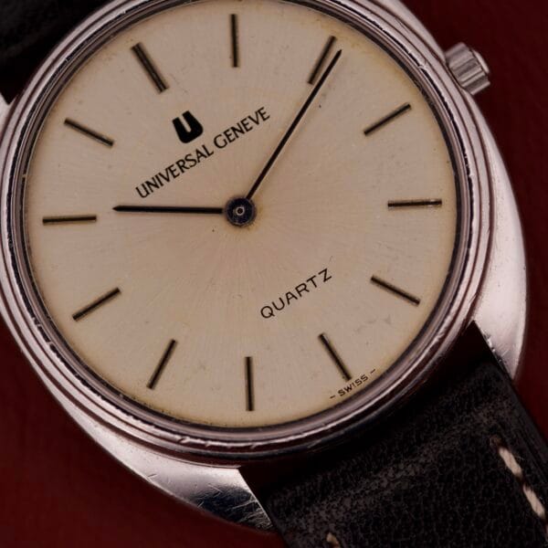 Close-up of a Universal Geneve Quartz Ref. 874 108 wristwatch with stainless steel cushion case, cream dial, and black leather strap.