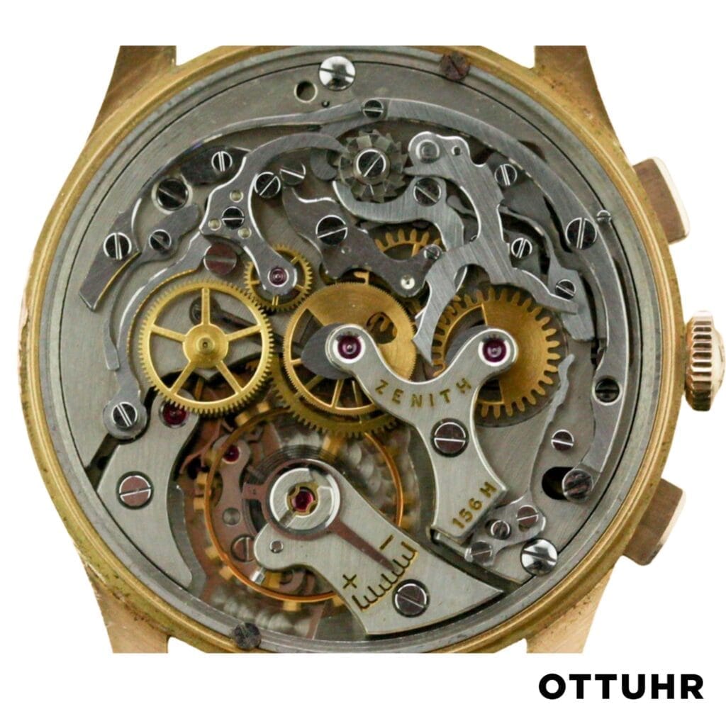 Close-up of an intricate mechanical watch movement, labeled Zenith 156H, showcasing visible gears and finely crafted parts.