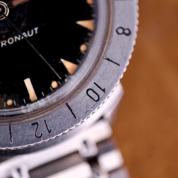 Close-up of a Bulova Accutron Astronaut 214 GMT 24 Hour Bezel Black Dial, displaying the numbered bezel with GMT markings, part of the black dial, and its metal bracelet.