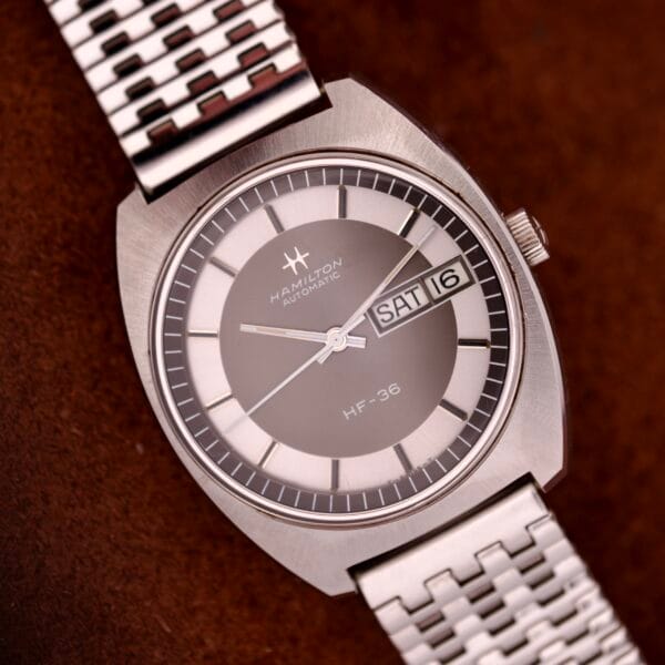 The Hamilton Automatic HF-36 Day-Date Hi-Beat Cal. 631 features a silver dial, metal bracelet, automatic movement, and displays the day and date (SAT 16).
