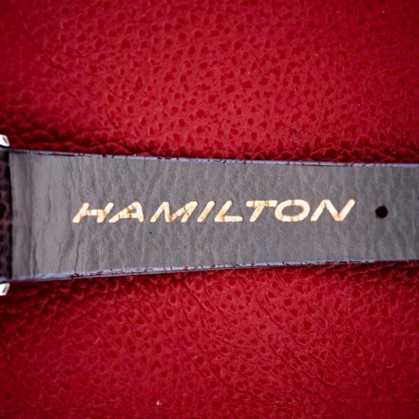 A black leather strap with HAMILTON in gold on textured red, inspired by the Hamilton Thin-o-matic T-500 Caliber 666 Automatic Micro-Rotor and its iconic design.
