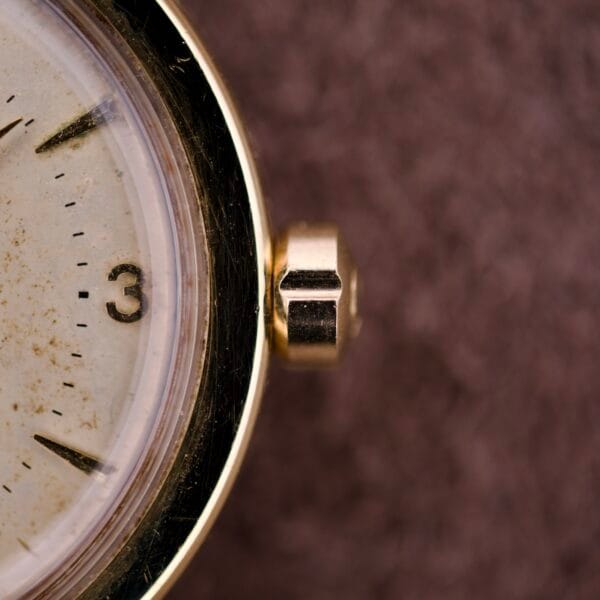 Close-up of the Omega Automatic Seamaster Ref. 14363, featuring its gold crown and part of the dial at three o’clock, highlighting the 14k Gold Capped Bull Horn Lugs.