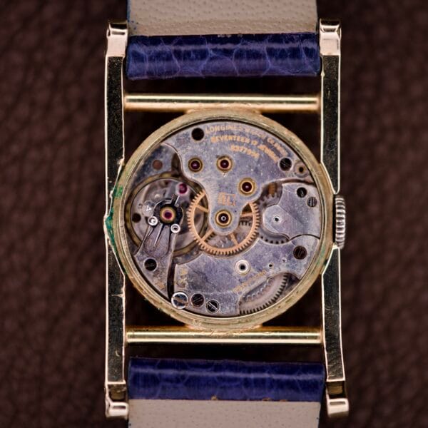 Close-up of a vintage Longines Mainliner Art Deco Drivers Watch, featuring the exposed manual wind Cal. 8L movement and intricate mechanical components.