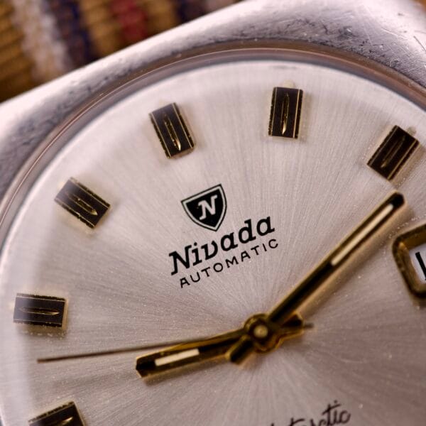 Close-up of the Nivada Automatic Antarctic Iceberg Date Ref. 4297 Sunburst Dial, showcasing gold hands, rectangular hour markers, and a captivating sunburst dial design.