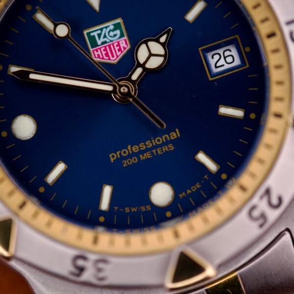 Close-up of a Tag Heuer 1500 Series Blue Sunburst Dial Ref. WD 1221-K-20, showcasing the hands, date window, and “Professional 200 meters” text on its vibrant blue sunburst face.
