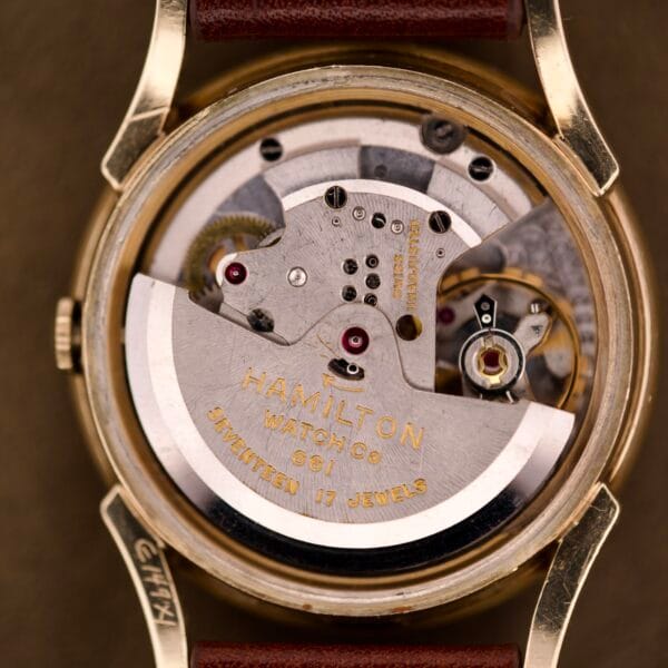 Close-up of a Hamilton Automatic Ref. K-407 with 10k Gold Filled Case, featuring Cal. 661 movement, visible gears, and SEVENTEEN 17 JEWELS engraved on the mechanism.