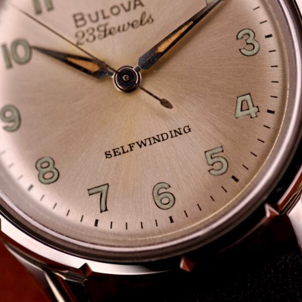 Close-up of a 1970 Bulova 23 Jewels Self-Winding Cal. 10BZAC watch face at 9:11, with "Self-Winding" and "23 Jewels" elegantly above the 6, set in a stainless steel case.