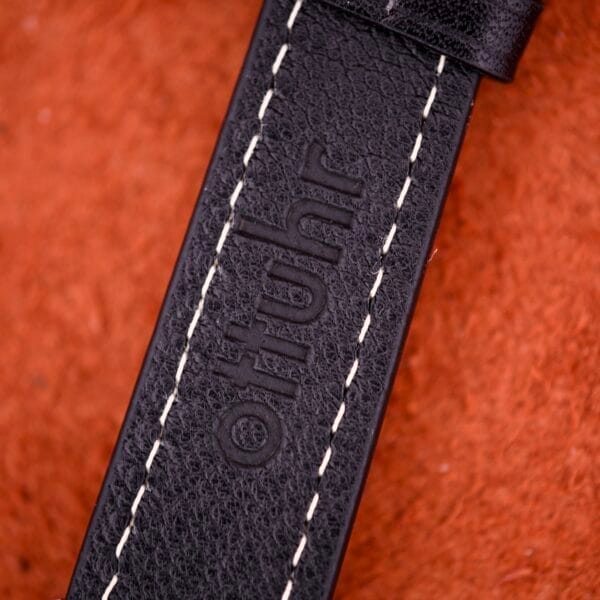 Close-up of a black leather strap with white stitching and "oltuhr" embossed, perfectly complementing the 1970 Bulova 23 Jewels Self-Winding Cal. 10BZAC stainless steel case timepiece.