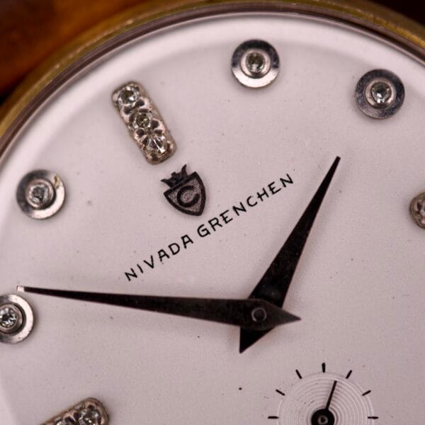 Close-up of the Nivada Grenchen Manual Wind Cal. R34 featuring a white dial with diamond markers and black hands at 2:00, showcasing its refined, elegant design.