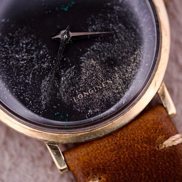 Close-up of a 1970s Longines Manual Wind wristwatch, showcasing a black dial with diamond marker and paired with a brown leather strap.