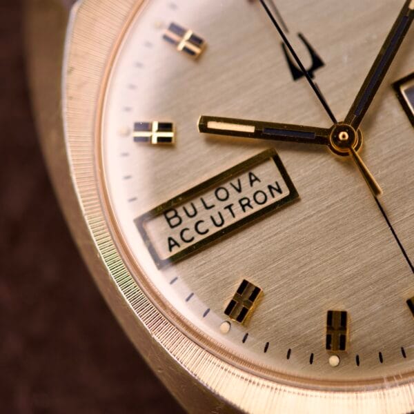 Close-up of a Bulova Accutron Turning Fork Cal. 2182 Day-Date Cushion Case watch face, highlighting the hands, hour markers, and Day-Date display.
