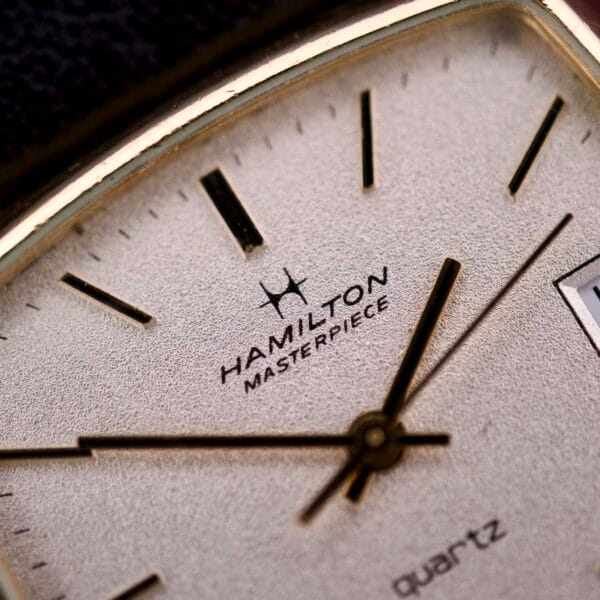 Close-up of the Hamilton Masterpiece Ref. 9116, featuring a quartz movement and date window in a 10K gold filled TV case.