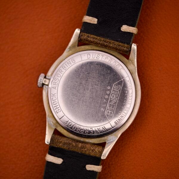 Back of a Benrus Shock-Absorber Tropic Dial Silver Indicies wristwatch with leather strap, showcasing engravings on the stainless steel case and highlighting the Shock-Absorber feature.
