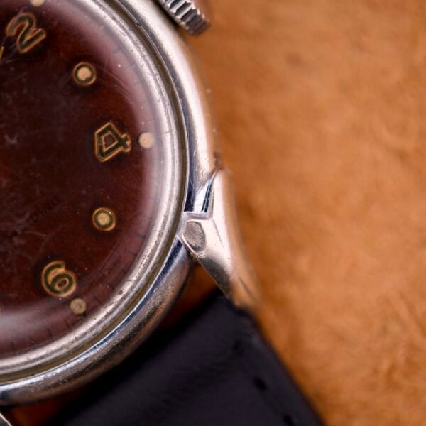 Close-up of a Benrus Three Star Automatic with browned tropic dial and stainless steel case, featuring visible numerals 2, 4, and 6.