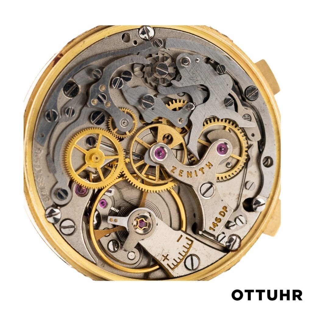 Close-up of a Zenith 146DP mechanical watch movement, featuring golden gears and intricate metal parts.