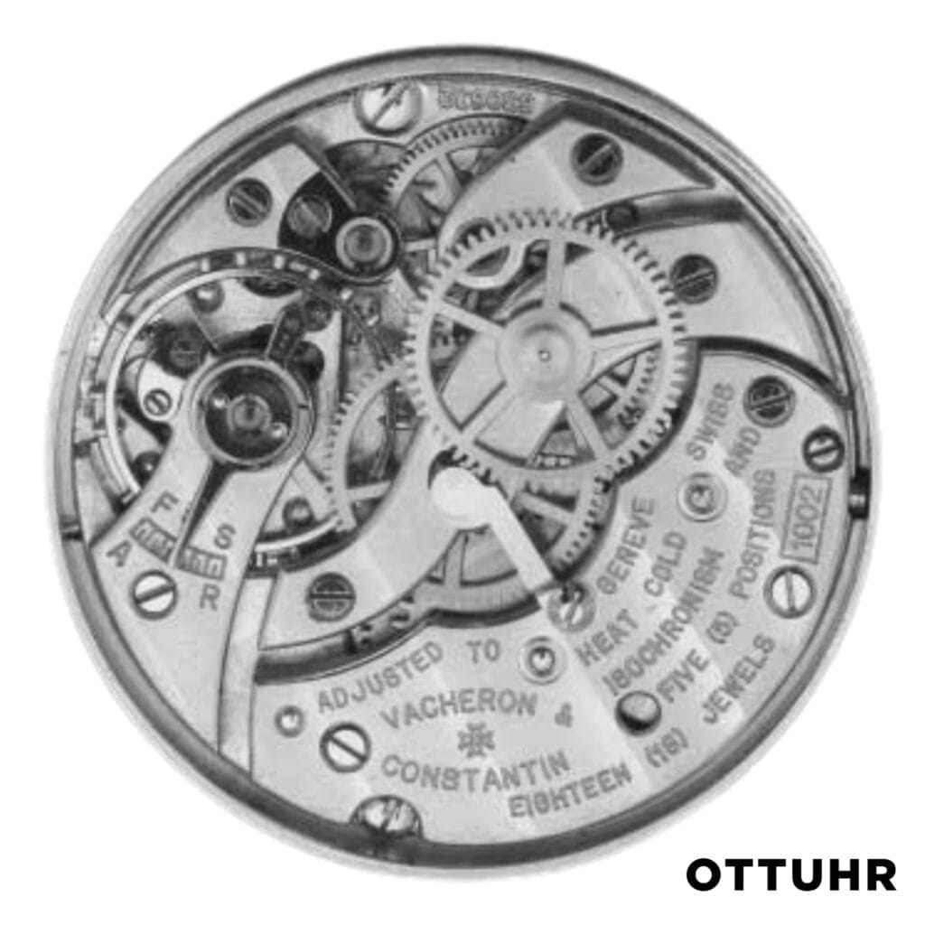 Close-up of a Vacheron Constantin mechanical watch movement, revealing intricate gears, cogs, and engraved text, with K1002 and OTTUHR at the bottom right.