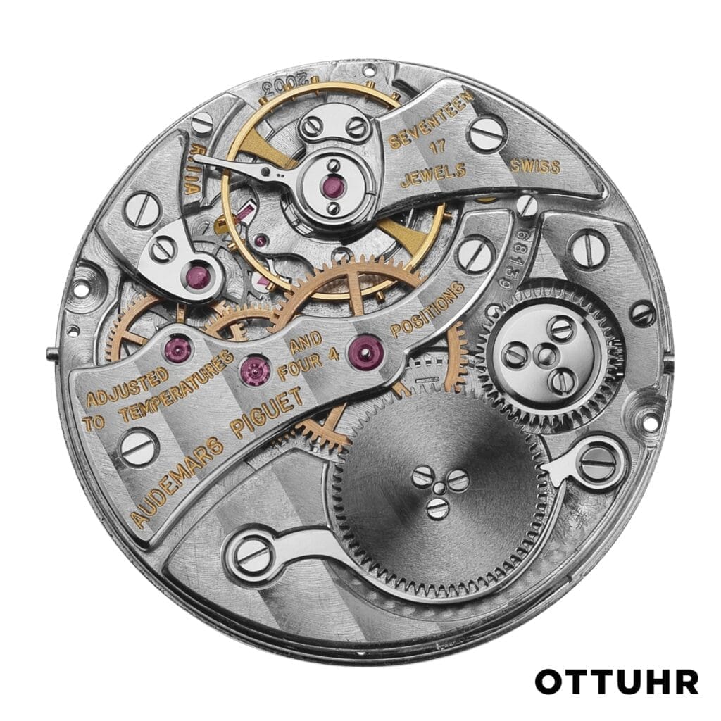 Close-up of a mechanical watch movement, showcasing its intricate gears, screws, and engraved text on the metal surface—highlighting the precision of its 2003 caliber design.