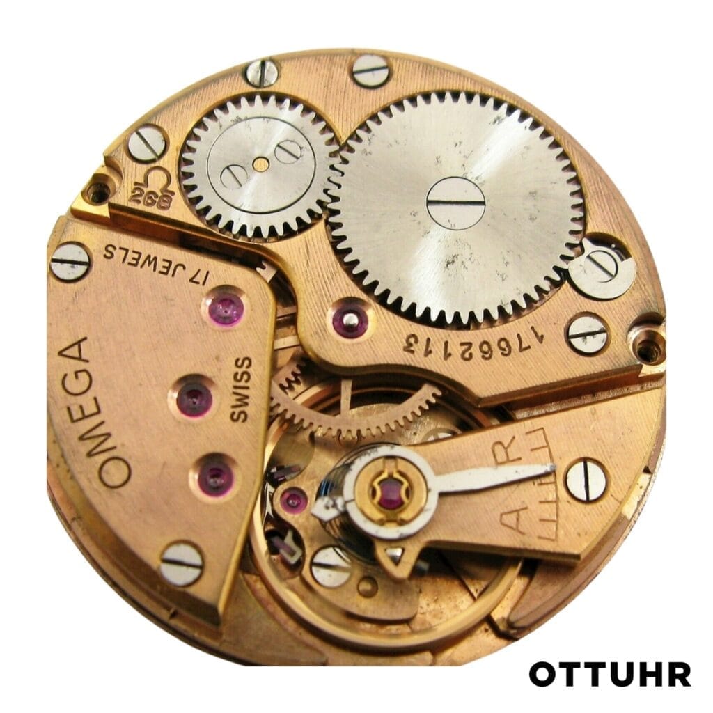 Close-up of a vintage Omega 268 watch movement with visible gears, featuring “OTTUHR” text in the bottom right corner.