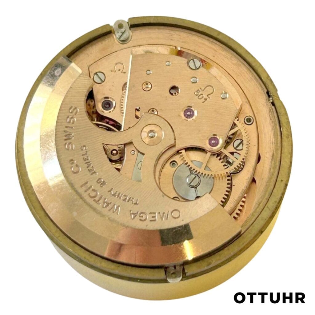 Close-up of an Omega 501 Swiss watch movement with visible gears, labeled OMEGA WATCH Co SWISS.