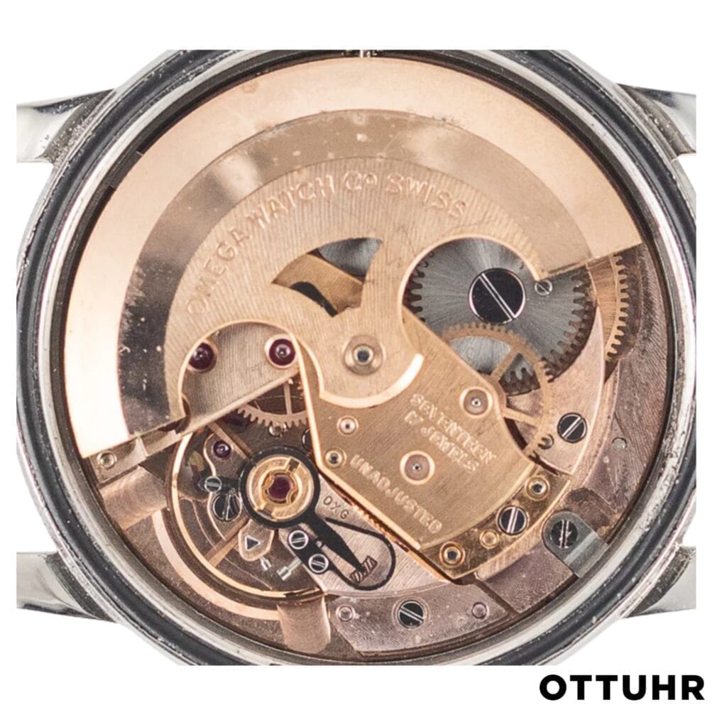 Close-up of a vintage gold Swiss watch movement with visible gears and intricate mechanical parts, featuring the renowned 560 caliber.
