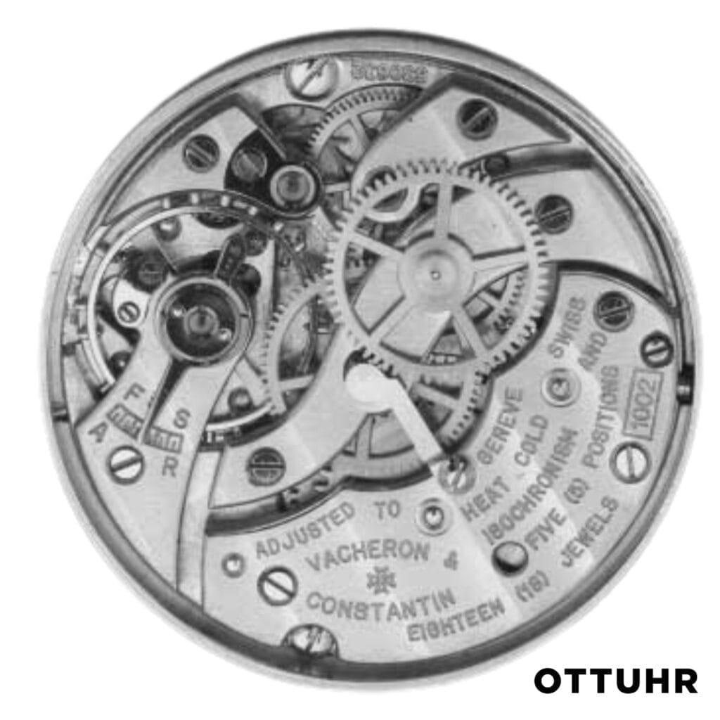 Close-up of a mechanical watch movement with visible gears and engraved markings, featuring the precision of a Vacheron Constantin K1002, labeled OTTUHR in the corner.