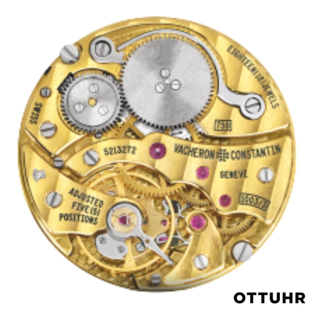 Close-up of a Vacheron Constantin 1003 gold mechanical watch movement with visible gears and engraved text, viewed from above.