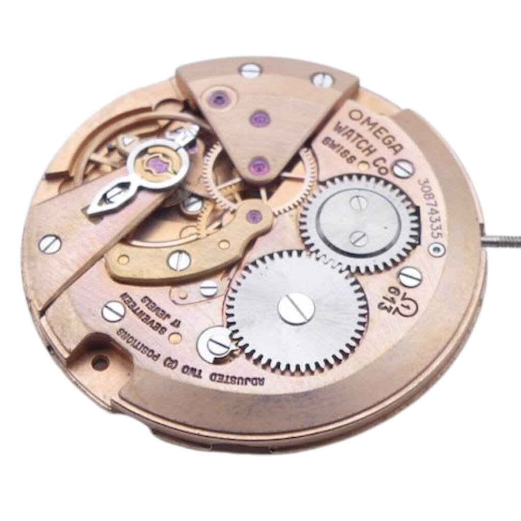 Close-up of a vintage Omega 613 watch movement, showcasing visible gears and engraved text on the metal parts.