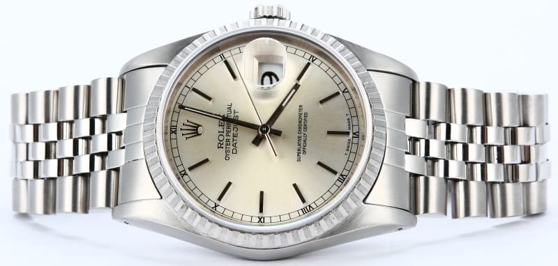 A silver Rolex Datejust wristwatch with a metal band and a light-colored dial displaying the time and date.