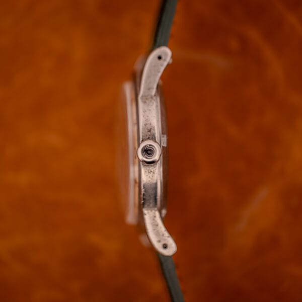 Profile side view of Omega Seamaster 2576-14 case showing signed Omega crown and downturned lug curve