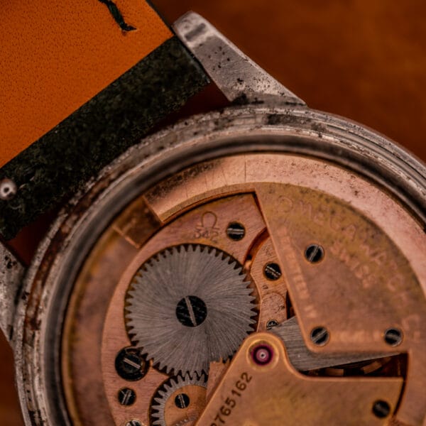 Close-up of Omega Caliber 342 bumper movement bridges showing Omega logo and bumper spring buffers