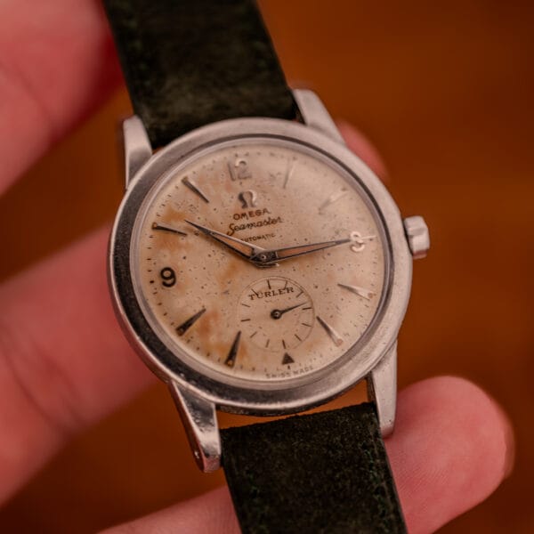 In-hand frontal view of Omega Seamaster Bumper with Türler signed sub-seconds dial and dauphine hands