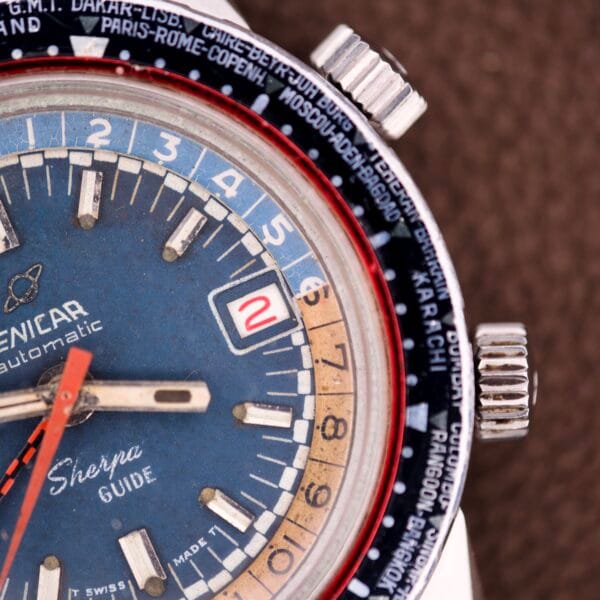 Close-up of the Enicar Sherpa Guide 600 "Pepsi" Automatic World Timer GMT Ref. 2342, featuring an Enicar-branded dial, date window, and city names on the bezel.