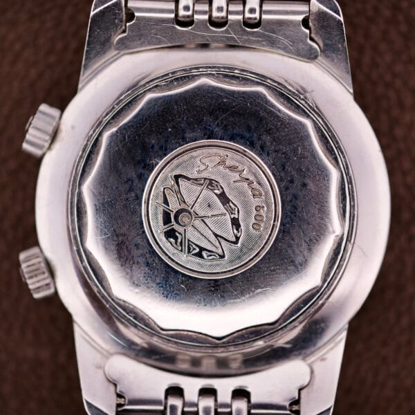 Close-up of a silver Enicar Sherpa Guide 600 "Pepsi" Automatic World Timer GMT Ref. 2342 case back, engraved with Sherpa 600 and a satellite dish image.