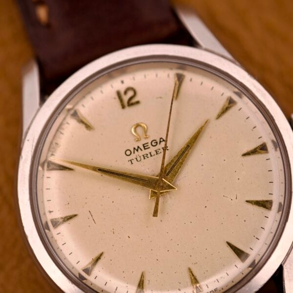 Close-up of an Omega Jumbo Ref. 2640 wristwatch with gold hands, "Türler" dial, and manual wind Cal. 283 movement.