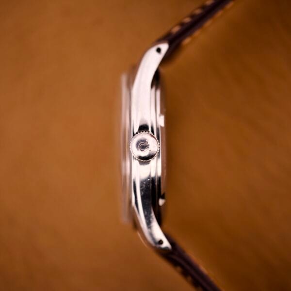 Side view of the Omega Jumbo Ref. 2640 Manual Wind Cal. 283 with a "Türler" Dial and brown leather strap, displayed on a brown background.