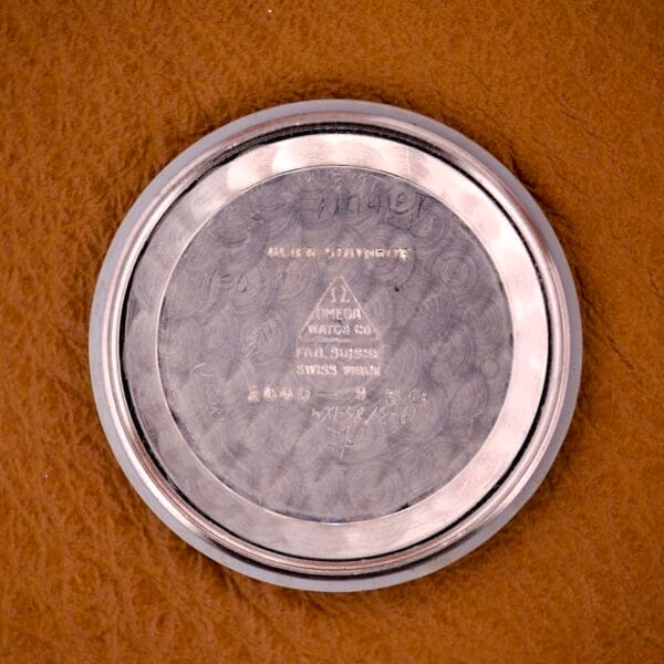 Round metal case back engraved with Omega Watch Co and other text, likely from an Omega Jumbo Ref. 2640 Manual Wind Cal. 283 "Türler" Dial, shown on brown leather.