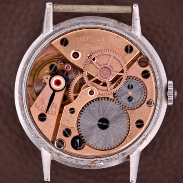 Close-up of the Omega Ref. 2338 Jumbo, showcasing its stainless steel case and detailed Caliber 30T2 SC movement with visible gears and mechanical components.